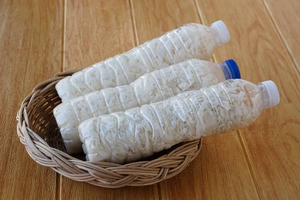 Plastic bottles filled with shredded bamboo shoots for pickling of the preservation food on brown wooden floor. Concept,  reuse plastic bottle. Zero waste. Thai wisdom of food preservation.  DIY.
