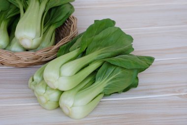 Fresh Bok Choy or Pak Choi or Chinese cabbage on wooden background and in basket for cooking. Concept, Organic vegetables. Healthy food. High fibers and vitamins.     