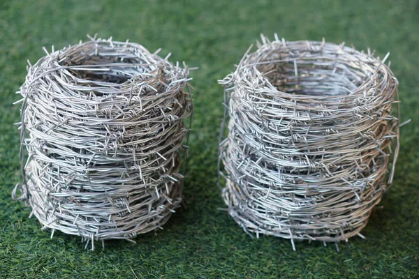 Rolls of barbed wire. Barbed wire is used for make fences , secure property and make border to show the territory of  area.