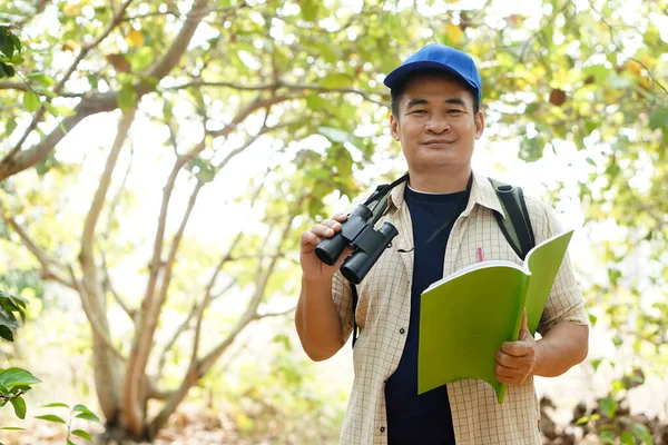 Азиатский Исследователь Носит Синюю Шапку Держит Бинокль Лесу Обследовать Ботанические — стоковое фото