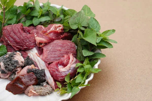 Fresh raw beef and Thai local herbal vegetables, prepare for cooking. Concept, food ingredient. Tradiotnal weird food. Popular menu in northern of Thailand.  Local food. Food ingredients to cook Larb.
