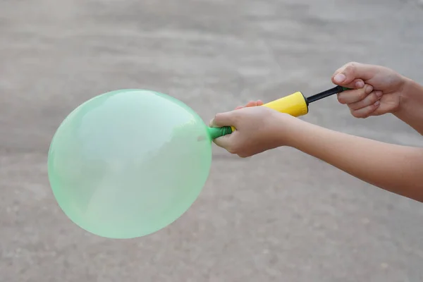 Blowing green balloon by hand air pump, inflates  air to balloon Concept, children play, toy and equipment to play fun games or prepare party.