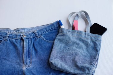 Beyaz arka planda eski mavi kot pantolonlardan yapılmış el yapımı çevre dostu DIY çanta. Diy konsepti. Geri dönüşümlü fikir. Alışveriş ve alışveriş için tekrar kullanılabilir torba ya da bir şeyler koymak için. Çevre dostu. Sıfır kayıp. Üst görünüm.       