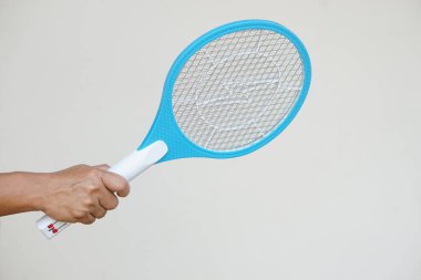 Kapalı el sivrisinek elektrikli sopa raketi tutuyor. Konsept, sivrisinekleri, böcekleri, böcekleri öldürmek için uçan böcekleri ezmek için elektrikli cihaz..                          