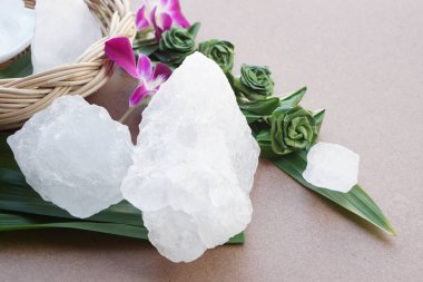 Crystal clear alum stones or Potassium alum, decorated with flowers and leaf. Useful for beauty and spa treatment. Use to treat body odor under the armpits as deodorant and make water clear.  clipart
