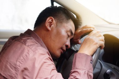 Asyalı adam arabada uyuyakalır, araba sürerken biraz kestirir. Kavram, sarhoş, bitkin, hastalıklı semptomlar ya da araba kazasına neden olabilecek olumsuz duygularla araba sürmeyi bırakma kampanyası..