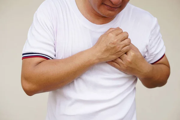 Closeup  Asian man  feels hurt his chest, suffering from chest pain. Concept, Heart attack , heart disease, stroke symptoms. Health problem. Sick and illness.