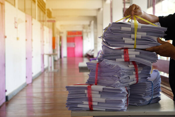 Руки крупным планом держат стопку использованной бумаги, комбинируются для использования в следующий раз или берут на переработку. Концепция, экологически чистая деятельность. Управление отходами бумаги. Сокращение повторного использования, переработки бумаги.