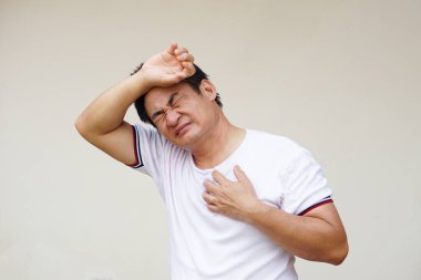 Asyalı bir adam sıcak, rahatsız edici, sıcak hava bunaltıcısından mutsuz, bu da sıcak çarpmasına, hastalığa ya da hastalığa neden olabilir. Sağlık ile küresel ısınma etkisi kavramı.     