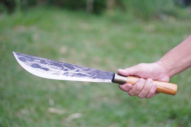 Closeup hand holds vintage knife in the evening light. Concept : Tool or equipment in kitchen, use for chopping, cutting when cooking or other purposes as weapon, hunting. knives in local kitchen