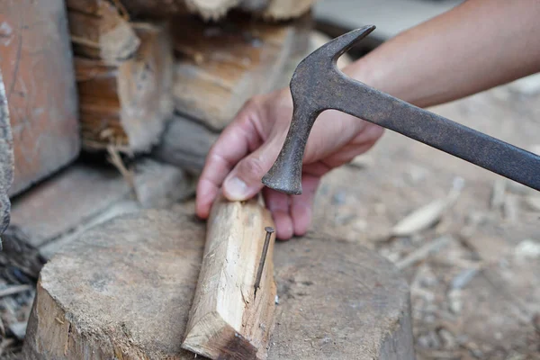 stock image Closeup carpenter use old hammer to hit metal nail on wood.  Concept, carpentry and construction tools. Repair or fixing, DIY woodwork.  Local lifestyle.