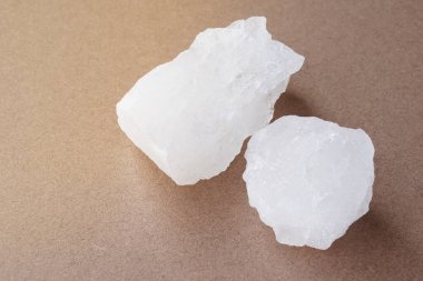 Kahverengi arka planda kristal berrak alyum taşları ya da potasyum alum. Güzellik ve kaplıca tedavisi için kullanışlı. Koltuk altlarındaki vücut kokusunu deodorant olarak kullanıp suyu berrak hale getirmek için kullanılır.. 