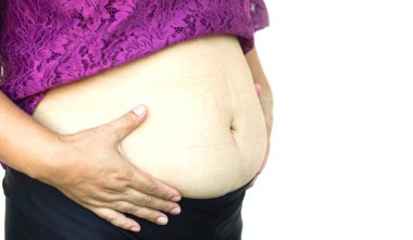 Kapalı kadın elleri büyük göbeğe dokunur, selüloit karın boşluğu ile şişmanlar. Kavram, obezite. Fazla kilolu. Hamilelikten sonra ya da yaşlandıktan sonra kadınlar için vücut şekli sorunu. Sağlık hizmetleri.    
