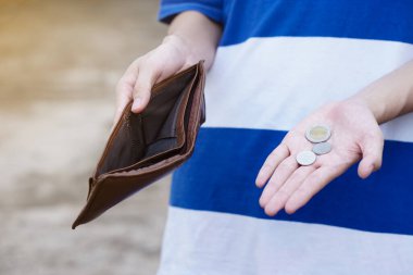 Boş cüzdanı tutarak ellerini kapat ve Tayland paralarını göster. Kavram, zayıf, kötü ekonomik kriz. Finansal sorunlar. Ay sonunda beş parasız ya da daha az..   