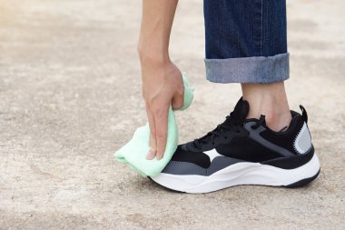 Kapalı el, yumuşak bez kullanarak toprağı ya da tozu temizler. Konsept, ayakkabılarına dikkat et. Uzun ömürlü kullanım için temiz, hijyenik ve hijyenik bakım. Ayakkabı giymek sağlıklıymış. spor ayakkabıları.