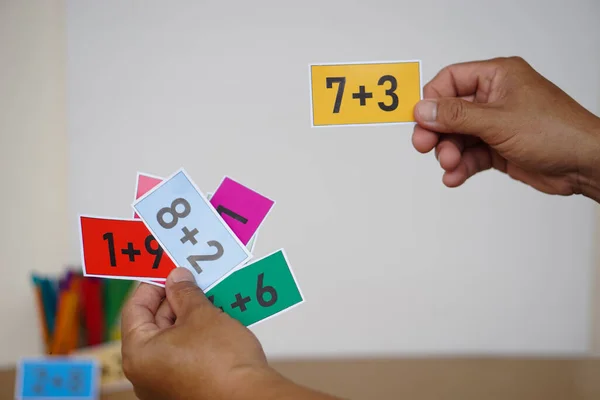 Kapanış öğretmeni, matematik dersi vermek için yanında rakamlar eklenmiş kağıtları da tutuyor. Konsept, eğitim, öğretim yardımı, çocuklar için malzemeler. Eğitim, Alıştırma Hesaplama           