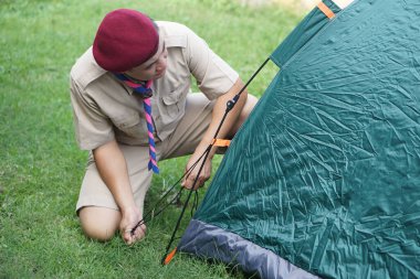 Taylandlı izciler kamp alanında kamp kurmak için çadır kuruyor. Kavram, kamp çadırı kurmak, geçici olarak açık havada uyumak için keşif yürüyüşü yapmak..     