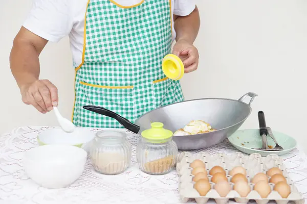 Close up man is cooking, fried eggs menu, pan , tray of eggs, bowls and jars of seasoning powder. Concept, love cooking. Fast and easy eggs menu. Food ingredient. Recipe. Kitchen lifestyle. Asian food