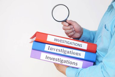 Bir dedektifin elinde soruşturma dosyaları ve büyüteç vardır. Kavram, suç. Kriminal soruşturma inceleniyor.             
