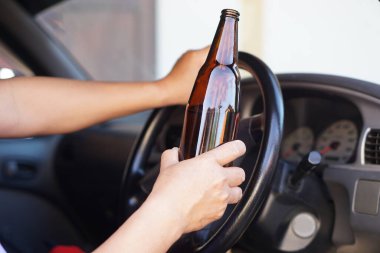 Sarhoş adam arabada bira şişesi tutuyor. İçki ya da viski içerken araba kullanmayı bırak. Kazaya yol açan aracı kullanmak yasadışı ve tehlikeli.   