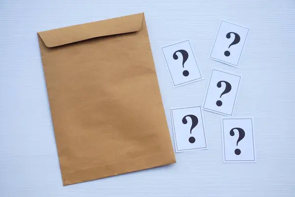 Brown envelope and paper cards of question marks. Concept. Teaching aid. Education materials for doing activity or playing investigation games about find answers.