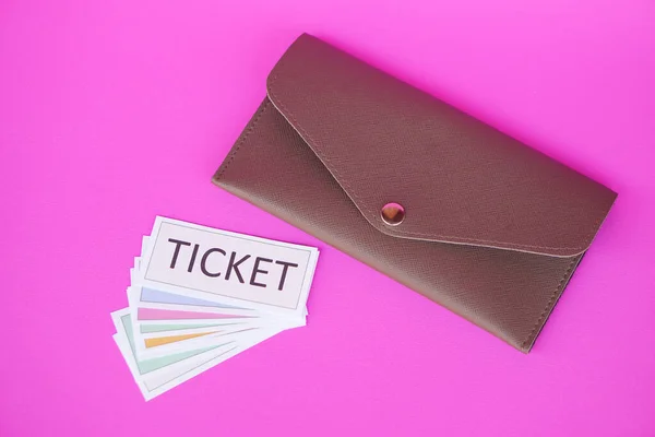 Leather envelope and pile of paper tickets. Pink background. Concept, tickets for passing or enter to join activity or public vehicles. Tickets for playing games. Teaching aids.