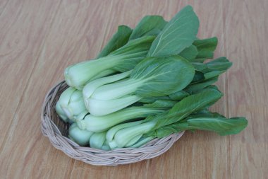 Fresh Bok Choy or Pak Choi or Chinese cabbage on wooden background and in basket for cooking. Concept, Organic vegetables. Healthy food. High fibers and vitamins.     