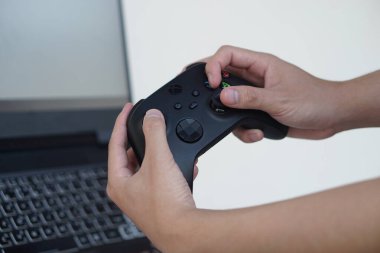 Kapalı eller siyah joystickleri ya da oyun kumanda konsolunu tutsun. Konsept, bilgisayar ekranına çevrimiçi uzak video oyunları hakkında eğlence için teknoloji aygıtı. Hobi, boş zaman ve eğlence aktivitesi.