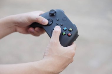 Kapalı eller siyah joystickleri ya da oyun kumanda konsolunu tutsun. Konsept, bilgisayar ekranına çevrimiçi uzak video oyunları hakkında eğlence için teknoloji aygıtı. Hobi, boş zaman ve eğlence aktivitesi.
