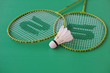 Mekik siki ve raketler. Badminton spor malzemeleri yeşil arka planda. Konsept, spor, egzersiz, iyi sağlık için eğlence etkinliği