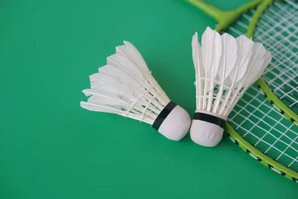 shuttlecock and rackets. Badminton sport equipments on green background. Concept, sport, exercise, recreation activity for good health