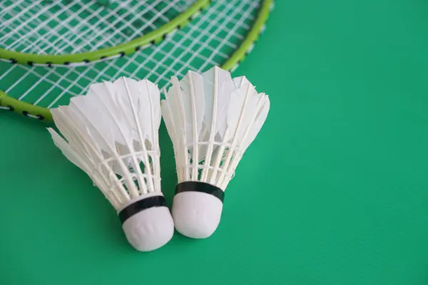 shuttlecock and rackets. Badminton sport equipments on green background. Concept, sport, exercise, recreation activity for good health