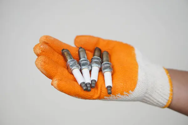 stock image Close up mechanic hands hold old spark plug, spare part of car engine. Concept, machine maintenance, fix, repair, check or diagnose automobile problems by engine specialist.       