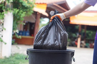 Çöp torbasını çöp kutusuna koyarak. Kavram, çöp yönetimi, en iyi çevre için hijyenik ve kamu hizmeti için temiz tutmak. Sıfır atık.                                  