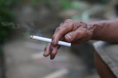 Sağlıksız elleri sigara içmek için ev yapımı sigara tutuyor. Sigara içmek sağlığa zararlıdır. Rahatlamak için özel favori ama sağlık sorunları ve kötü kokuya neden olabilir..     