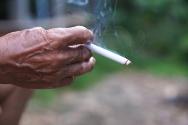 Sağlıksız elleri sigara içmek için ev yapımı sigara tutuyor. Sigara içmek sağlığa zararlıdır. Rahatlamak için özel favori ama sağlık sorunları ve kötü kokuya neden olabilir..     