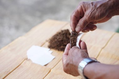 Elle rulo yapmak için sigara sarın. Sigara içmek sağlığa zararlıdır. Rahatlamak için özel favori ama sağlık sorunlarına neden olabilir Solunum hastalıkları ve bağımlı.                    