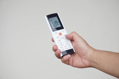 Klimanın uzaktan kumandasını kapat. Konsept, elektronik ekipman, uzaktan kumanda, çeşitli işlevlere sahip cihazları veya cihazları çalıştırmak için kullanılabilir. Sıcaklık kipini ayarla.    