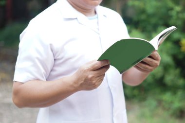 Yakından adam kitap okuyor. Kavram, kişisel çalışma, bilgi, zevk ya da kişisel gelişim için kitap okumak günlük hayatta bilgiyi uygulamak. Hazırlık sınavı için oku.   