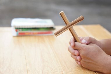 Hristiyan adamın elinde dua etmek için tahta bir haç var. Hristiyan ibadeti kavramı. İnanç, bağışlanma, inanç, aşk, umut, barış ve mutluluk. Haç, Hıristiyanlığın dini sembolü.. 