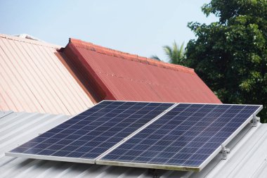 Çatıdaki fotovoltaik veya güneş panelleri. Güneş enerjisini ev için elektrik, çevre için temiz enerji üretmek için kullanan kavram. Yenilenebilir enerji, Doğal güç