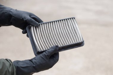 Kapalı mekanik ellerinin kontrol etmek için araba motorunun hava filtre pedini tuttuğunu. Konsept, araba arızası, tamir ve bakım servisi. Kirli hava filtresinin hijyenik olarak değişmesi gerekiyor..    
