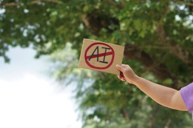 Close up hand holds paper card with No AI,  prohibition sign, outdoor nature background. Concept, disagree, anti or don't support to use AI or Artificial Intelligence in daily life.              clipart