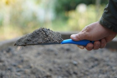Bahçede elle tutulan örnek toprak malasını kapatın. Tarım ürünleri için konsept, toprak kalitesi denetimi, araştırma ve geliştirme. Farklı toprak tipi ve kaynağından en iyisini bul