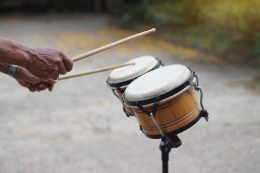 Yakından gelen adam bongo davullarını çalıyor. Konsept, müziğin ritmi için müzikal perküsyon enstrümanı performans ve dans için daha eğlenceli olur. Müzik ve şarkılar boyunca ritimle davul çal. 