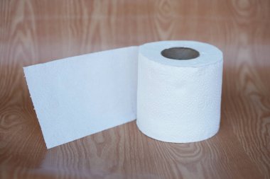  Kahverengi arka planda beyaz tuvalet kağıdı rulosu. Kavram, temizlik aleti, kirliliği temizlemek ve ıslaklığı emmek için hijyenik, günlük yaşamda hijyenik ve hijyenik kağıt kullanın..                                                        