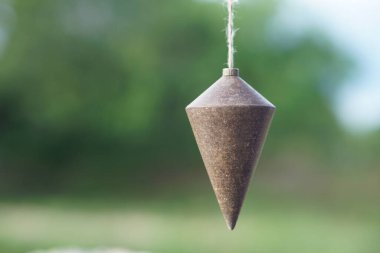 Ölçüm seviyesi için halatla sarkıtılmış eski bir tesisat bob, düşme veya konik demir, diklik belirlemek için kullanılır. Konsept, inşaat ve marangozluk için çalışma aracı.                                   