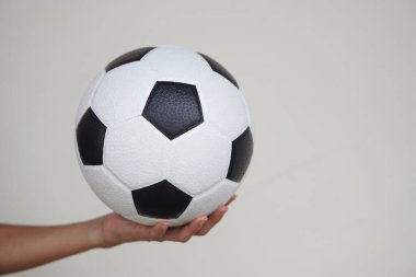 Eller futbol topunu tutuyor, futbol topunu. Konsept, spor malzemeleri. Spor, egzersiz, sağlık için egzersiz. Hobi olarak. Futbol maçı. Fiziksel ve zihinsel sağlığa iyi gelen eğlence aktivitesi.                                        