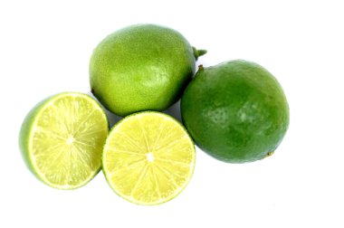 Yarısı kesilmiş ve yeşil limonlu meyveler, beyaz arka planda izole edilmiş. Konsept, organik tarım meyvesi baharatlı gıdalar için ekşi bir tat. Mutfak, sağlık ve doğal ürün temaları için ideal                               