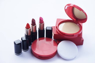 Zarif kırmızı pudralama yüz pudrası siyah tüpte eşleşen ruj yumuşak puf ve dahili aynayla sergileniyor. Parlak cilt ve kendine güvenen dudaklar için bir kavram. Modern kadınlar için ideal..                               